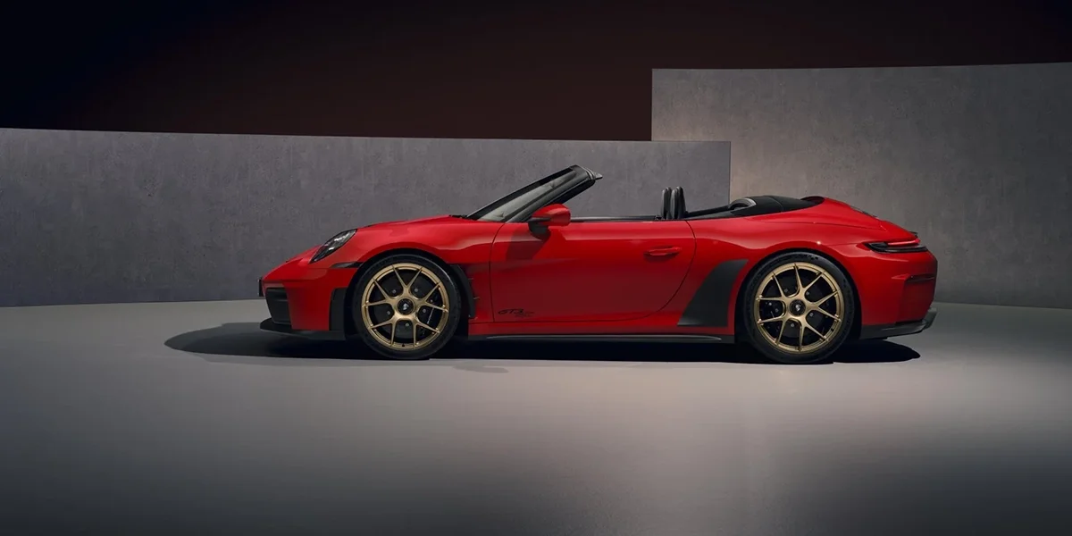 Side profile of red Porsche 911 GT3 RS Cabriolet highlighting low stance and gold wheels.